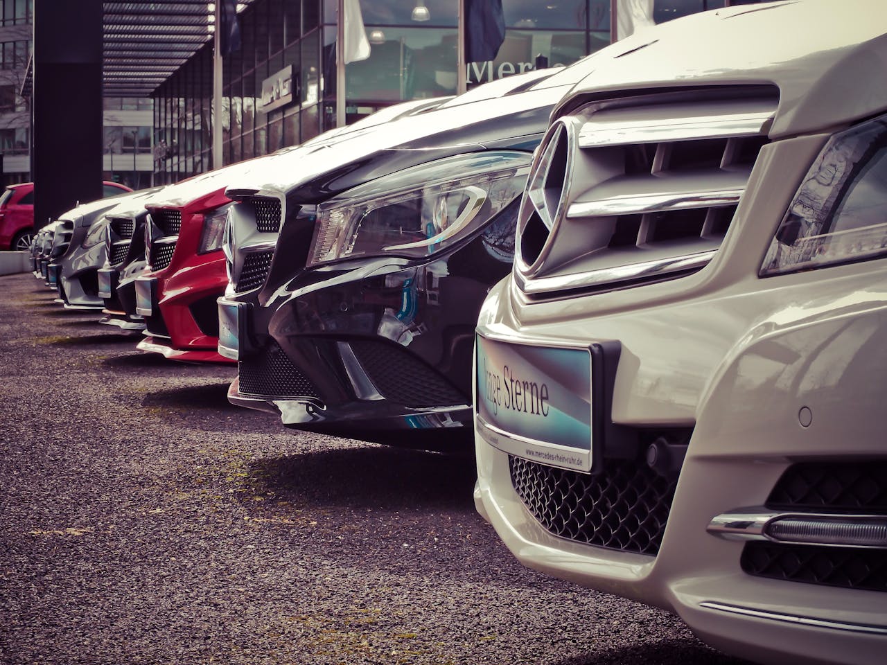 heros-img Luxury cars lined up at an outdoor dealership, showcasing sleek designs.